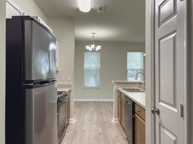 kitchen with a sink, freestanding refrigerator, dishwashing machine, light wood finished floors, and black range with electric stovetop
