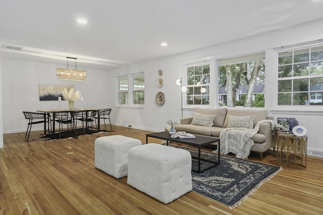 living room featuring wood-type flooring and an inviting chandelier