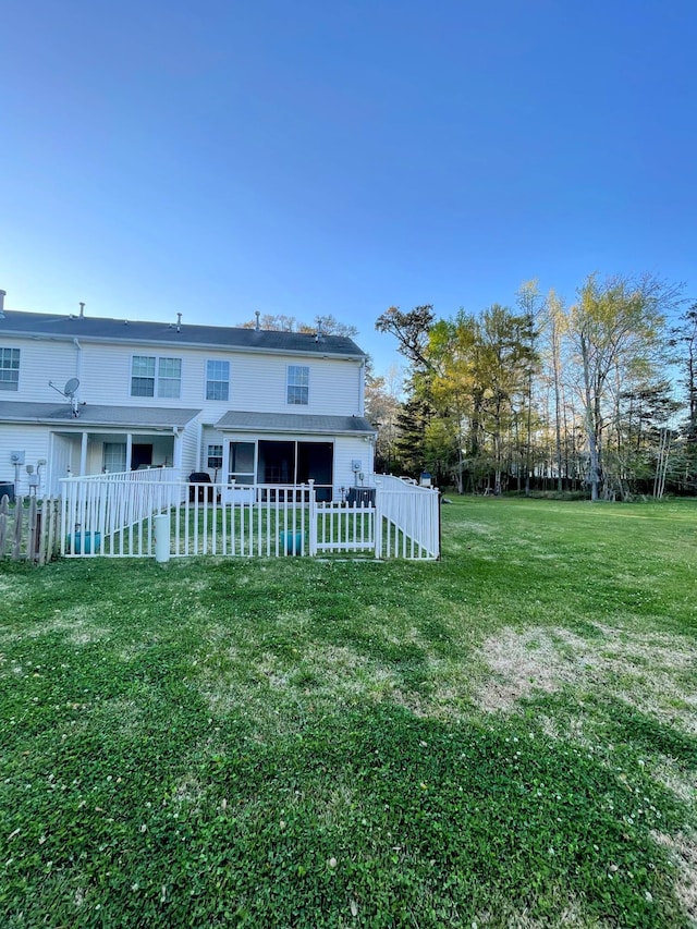 rear view of property featuring a lawn