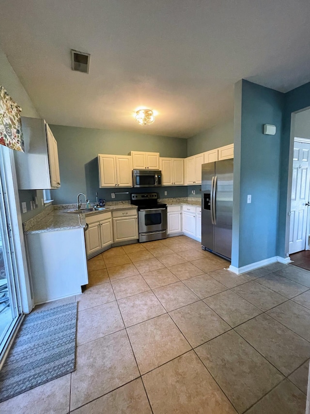 kitchen featuring appliances with stainless steel finishes, sink, and light tile patterned flooring