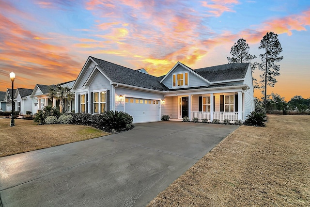 view of front of house with a yard, a garage, and covered porch