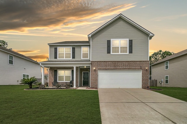 traditional-style house featuring brick siding, an attached garage, concrete driveway, and a lawn