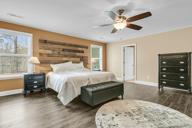 bedroom featuring visible vents, baseboards, dark wood-style floors, and a ceiling fan