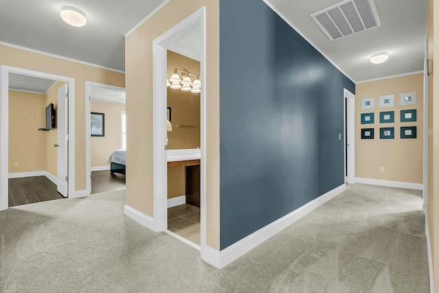 hall featuring visible vents, baseboards, carpet, and crown molding