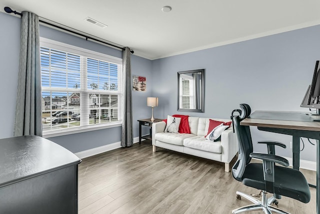 home office featuring visible vents, baseboards, wood finished floors, and ornamental molding