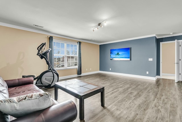 living room with crown molding, baseboards, and wood finished floors