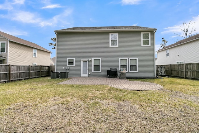 back of property with a fenced backyard, central air condition unit, a lawn, and a patio