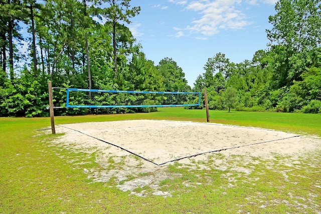 view of property's community featuring a yard, volleyball court, and a water view