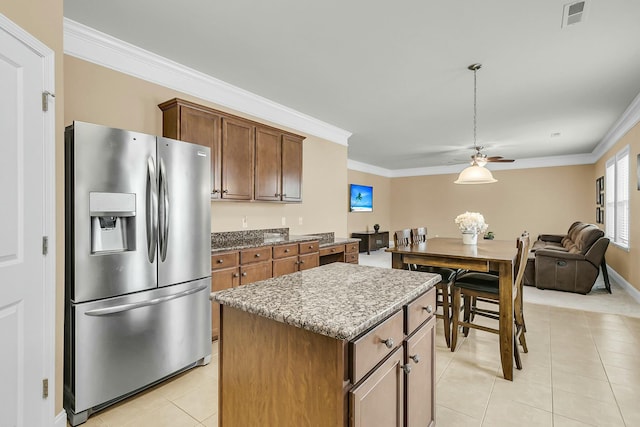 kitchen featuring a ceiling fan, visible vents, stainless steel fridge with ice dispenser, ornamental molding, and a center island