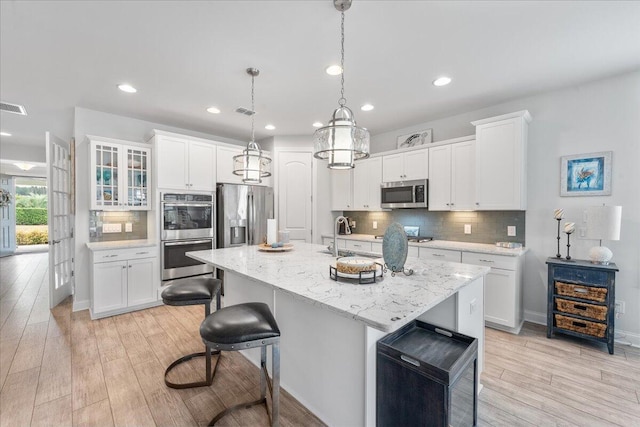 kitchen with white cabinetry, a kitchen island with sink, and appliances with stainless steel finishes