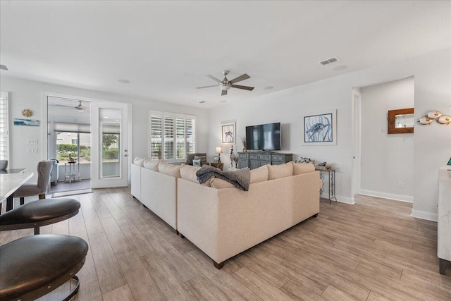 living room with ceiling fan and light hardwood / wood-style floors