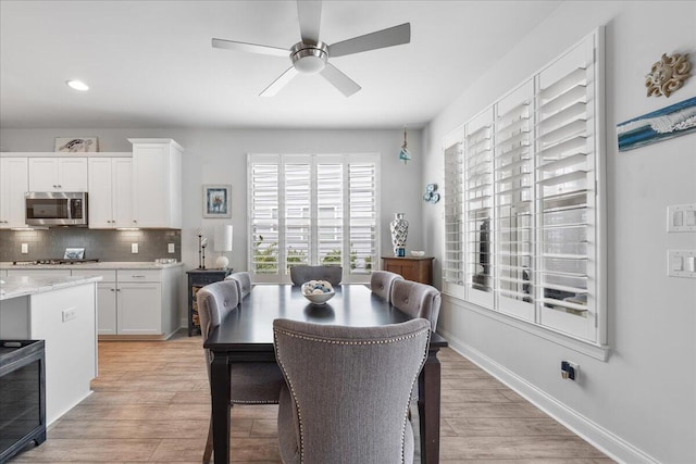 dining area with light hardwood / wood-style floors and ceiling fan