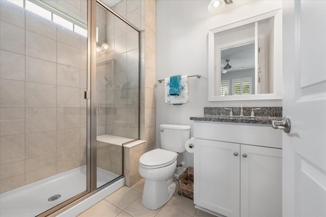 bathroom with vanity, walk in shower, ceiling fan, toilet, and tile patterned floors