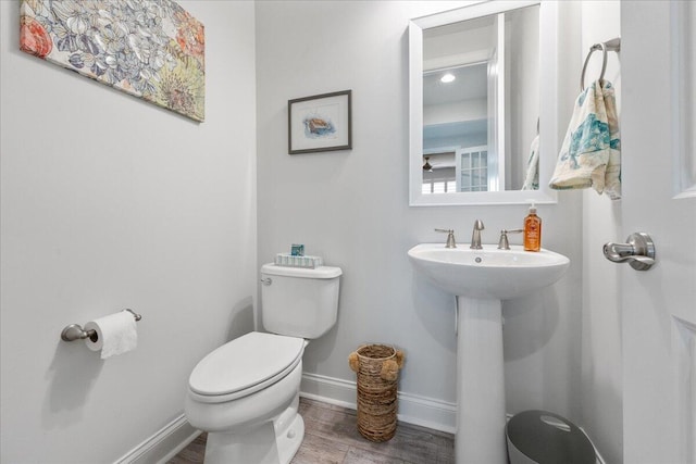 bathroom featuring wood-type flooring, toilet, and sink