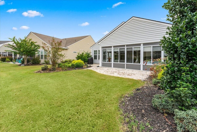 back of house featuring a sunroom, a lawn, and central air condition unit