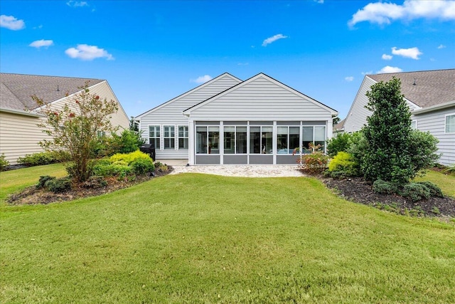 back of property with a lawn and a sunroom