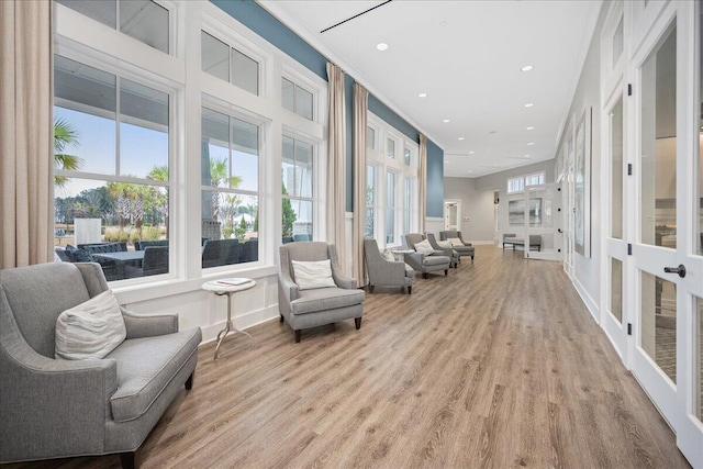 sitting room featuring ornamental molding and light hardwood / wood-style flooring