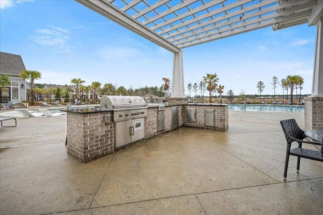 view of patio with exterior kitchen, a community pool, grilling area, and a pergola