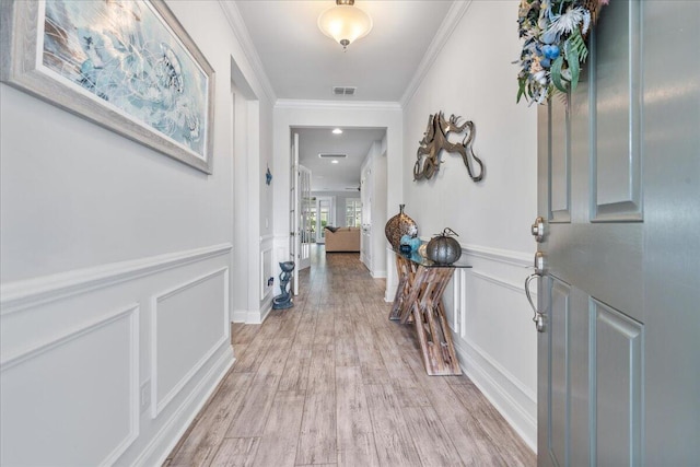 foyer entrance with crown molding and light wood-type flooring