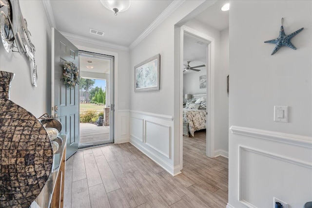 entrance foyer with ornamental molding and light wood-type flooring