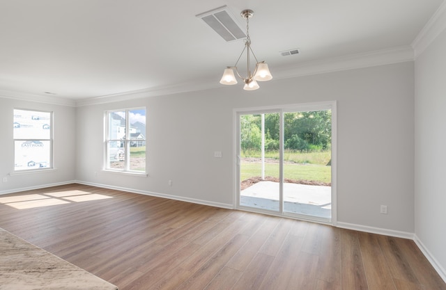 unfurnished room with visible vents, a notable chandelier, wood finished floors, and ornamental molding