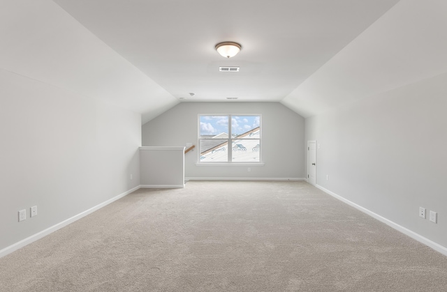 bonus room featuring lofted ceiling, carpet flooring, baseboards, and visible vents