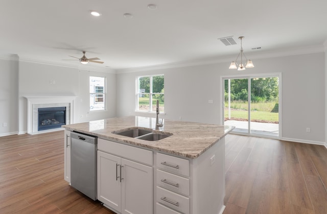 kitchen featuring visible vents, an island with sink, ornamental molding, a sink, and stainless steel dishwasher