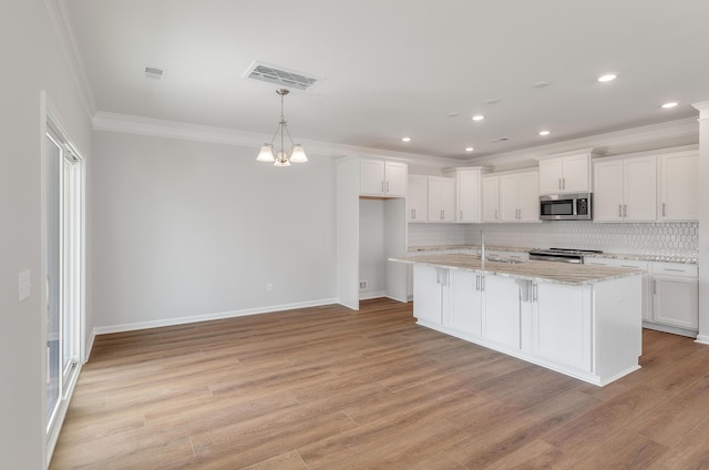 kitchen featuring visible vents, light wood finished floors, appliances with stainless steel finishes, white cabinetry, and backsplash