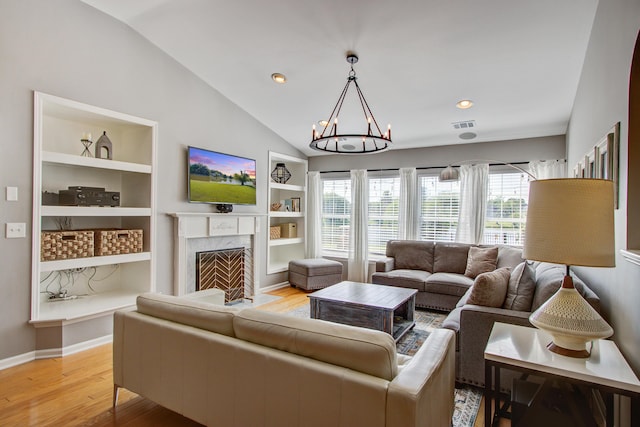 486 Maple Oak Ln, Charleston, SC 29414 - living area featuring built in features, a chandelier, light wood finished floors, vaulted ceiling, and a fireplace