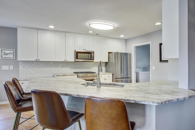 486 Maple Oak Ln, Charleston, SC 29414 - kitchen with stainless steel appliances, light wood-type flooring, a sink, white cabinets, and recessed lighting