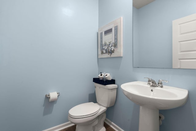 half bathroom with toilet and baseboards