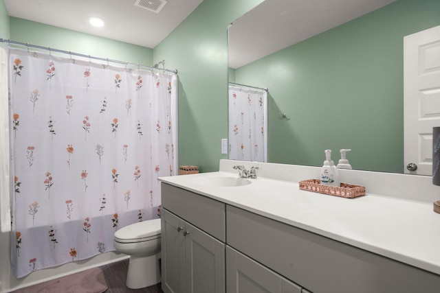 bathroom with toilet, vanity, and shower / bath combo