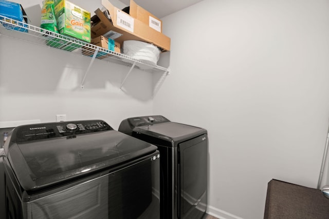 washroom featuring washing machine and clothes dryer and baseboards