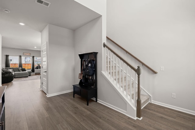 stairs featuring wood finished floors, baseboards, and recessed lighting