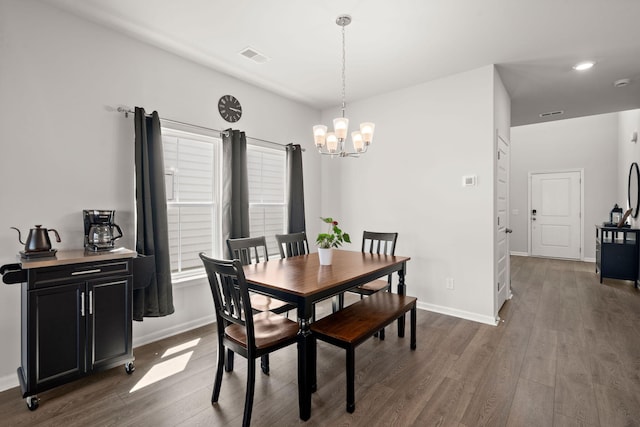 dining space featuring a chandelier, wood finished floors, and baseboards