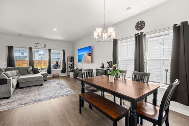 dining area with a chandelier, wood finished floors, and baseboards
