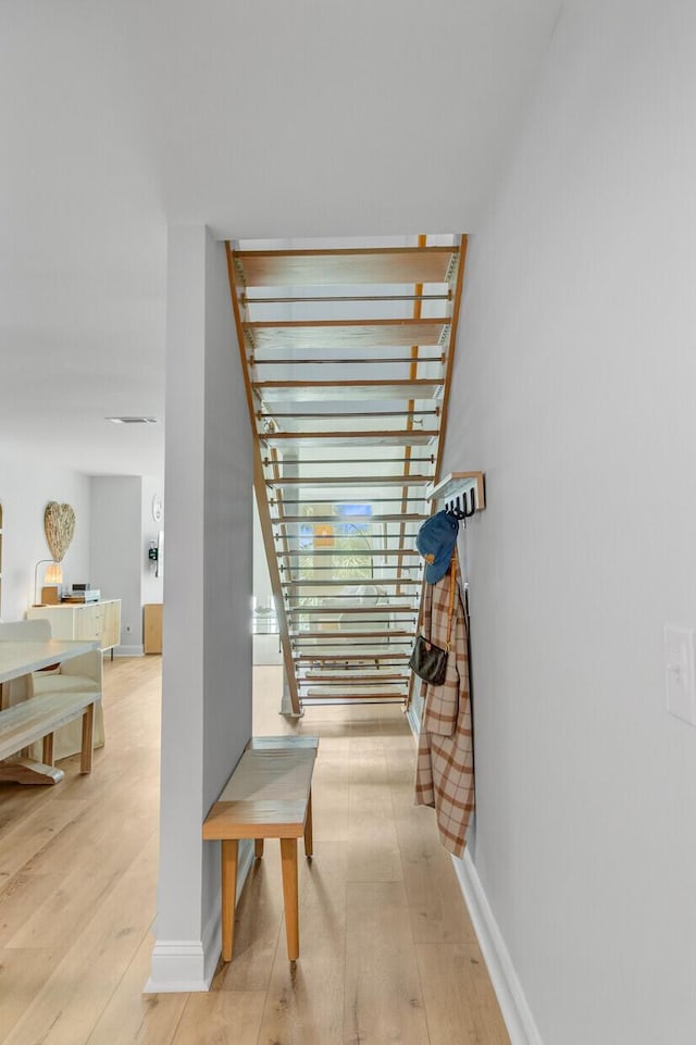 hallway featuring light wood-style flooring and baseboards