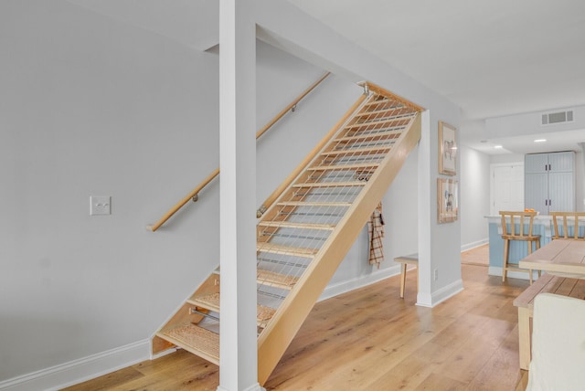 stairway with wood finished floors and baseboards