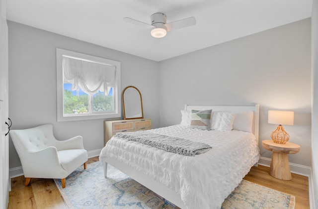 bedroom with baseboards, wood finished floors, and a ceiling fan