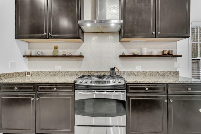 kitchen with wall chimney exhaust hood, stainless steel range with gas cooktop, open shelves, and dark brown cabinets