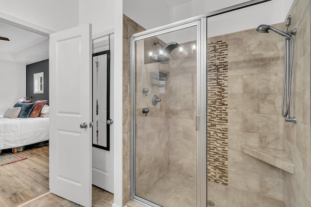 ensuite bathroom featuring a shower stall, connected bathroom, and wood finished floors