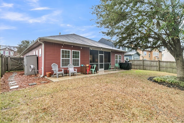 back of property featuring a lawn, a patio, a sunroom, a fenced backyard, and a gate