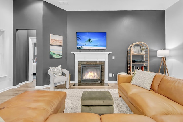 living area with a fireplace, baseboards, and wood finished floors