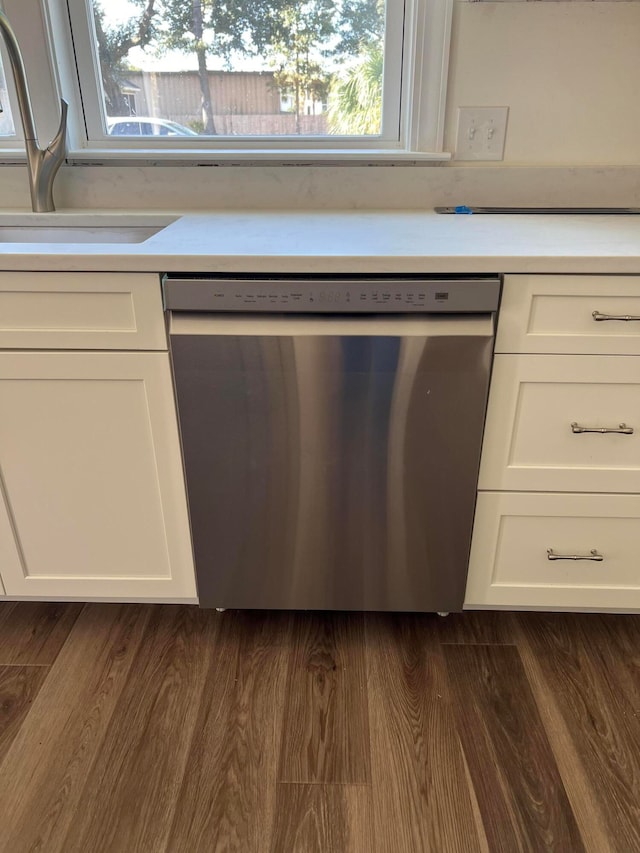 kitchen featuring white cabinetry, dark hardwood / wood-style flooring, stainless steel dishwasher, and sink