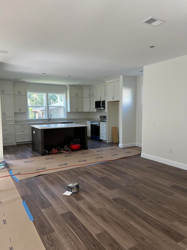 kitchen with dark hardwood / wood-style floors, a kitchen island, and electric range