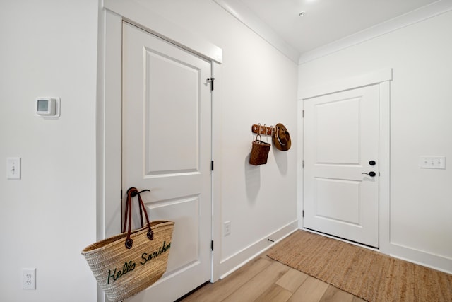 doorway to outside with hardwood / wood-style floors and ornamental molding