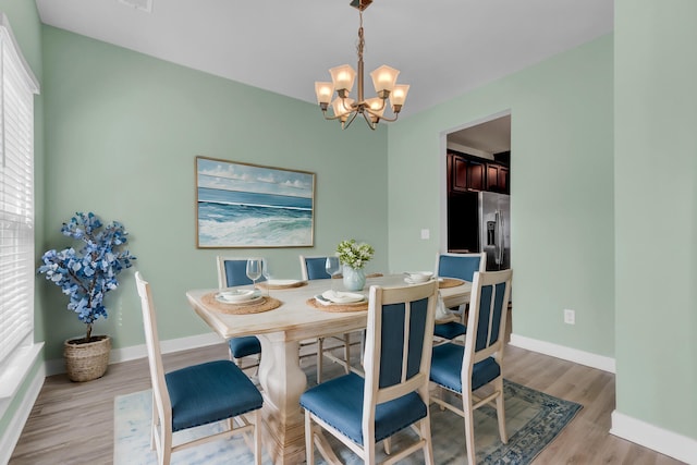 dining room featuring plenty of natural light, light hardwood / wood-style floors, and a notable chandelier