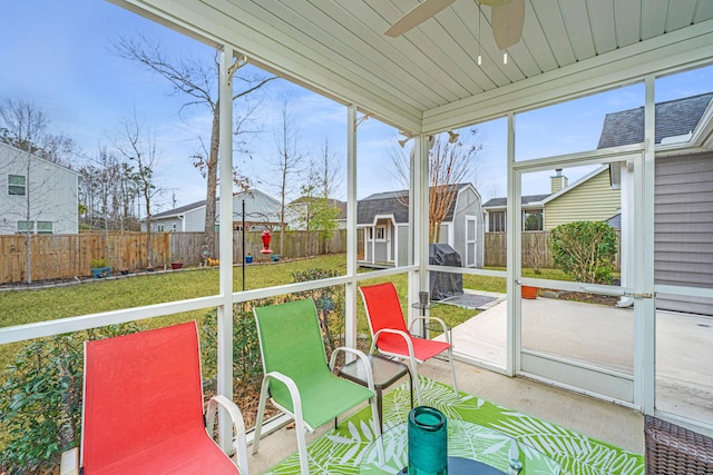 unfurnished sunroom featuring a ceiling fan