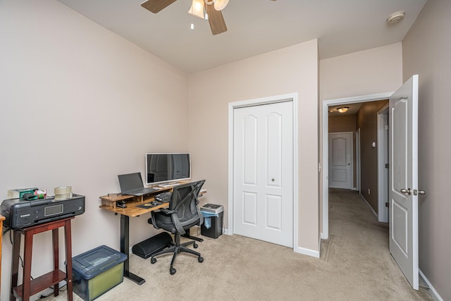 carpeted home office featuring a ceiling fan and baseboards