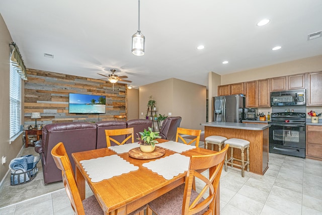 dining room featuring visible vents, recessed lighting, wood walls, ceiling fan, and an accent wall